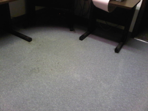 Improved and cleaned VCT tile floor by computer desk area after a professional stripping and waxing service albeit with some residual permanent damage from service neglect