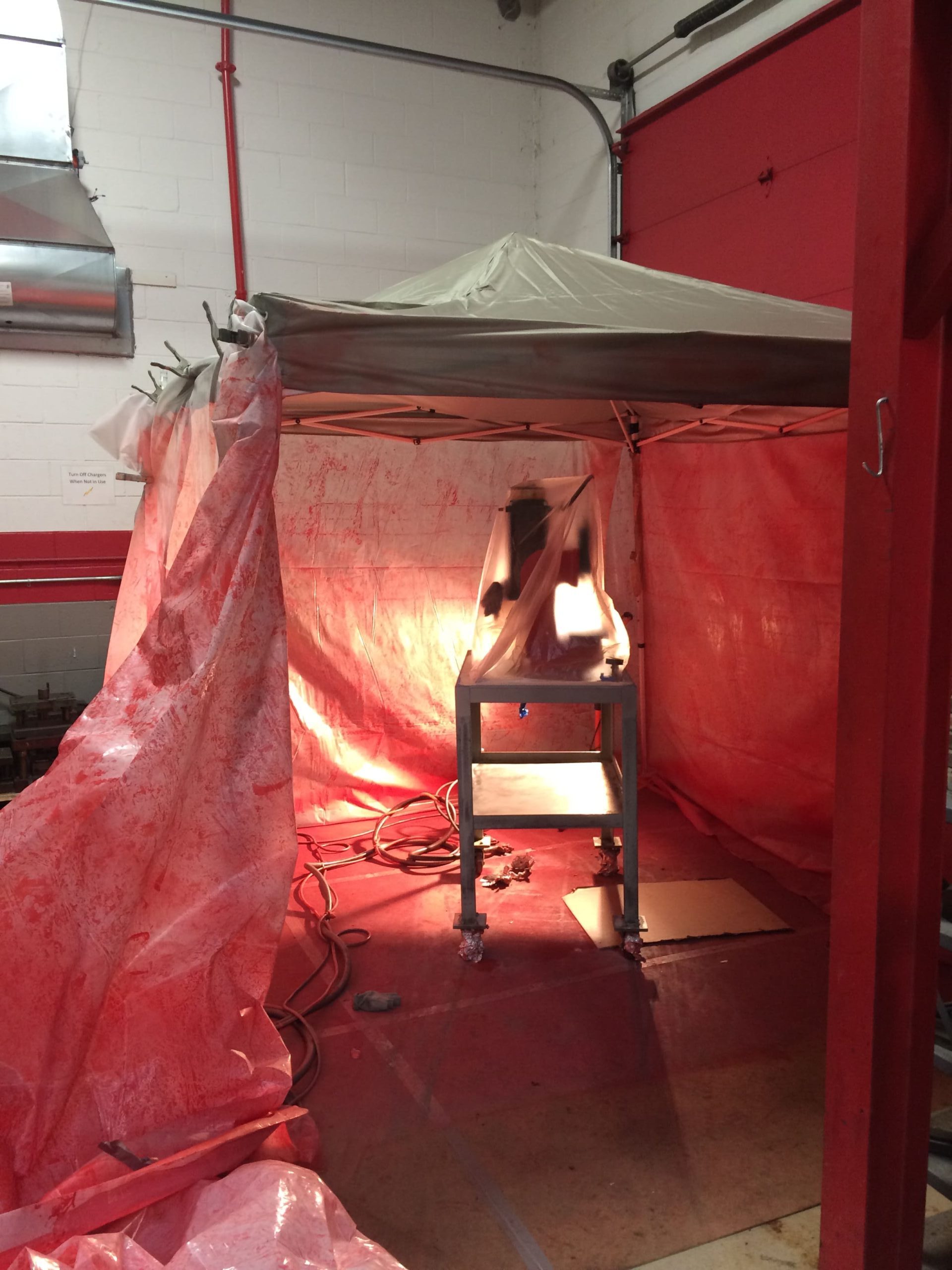 Tent with Machine inside being prepared for cleaning and painting inside a factory