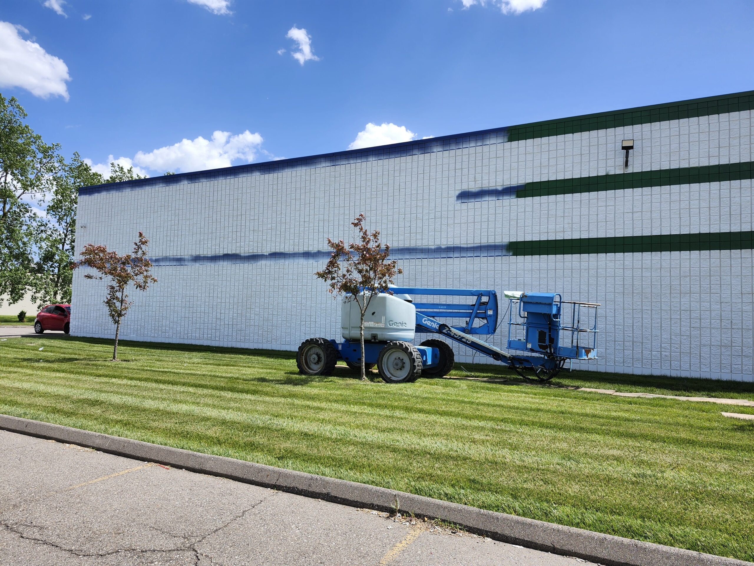 Commercial building being prepared for painting by Klein Cleaning with an aerial life in front of the building